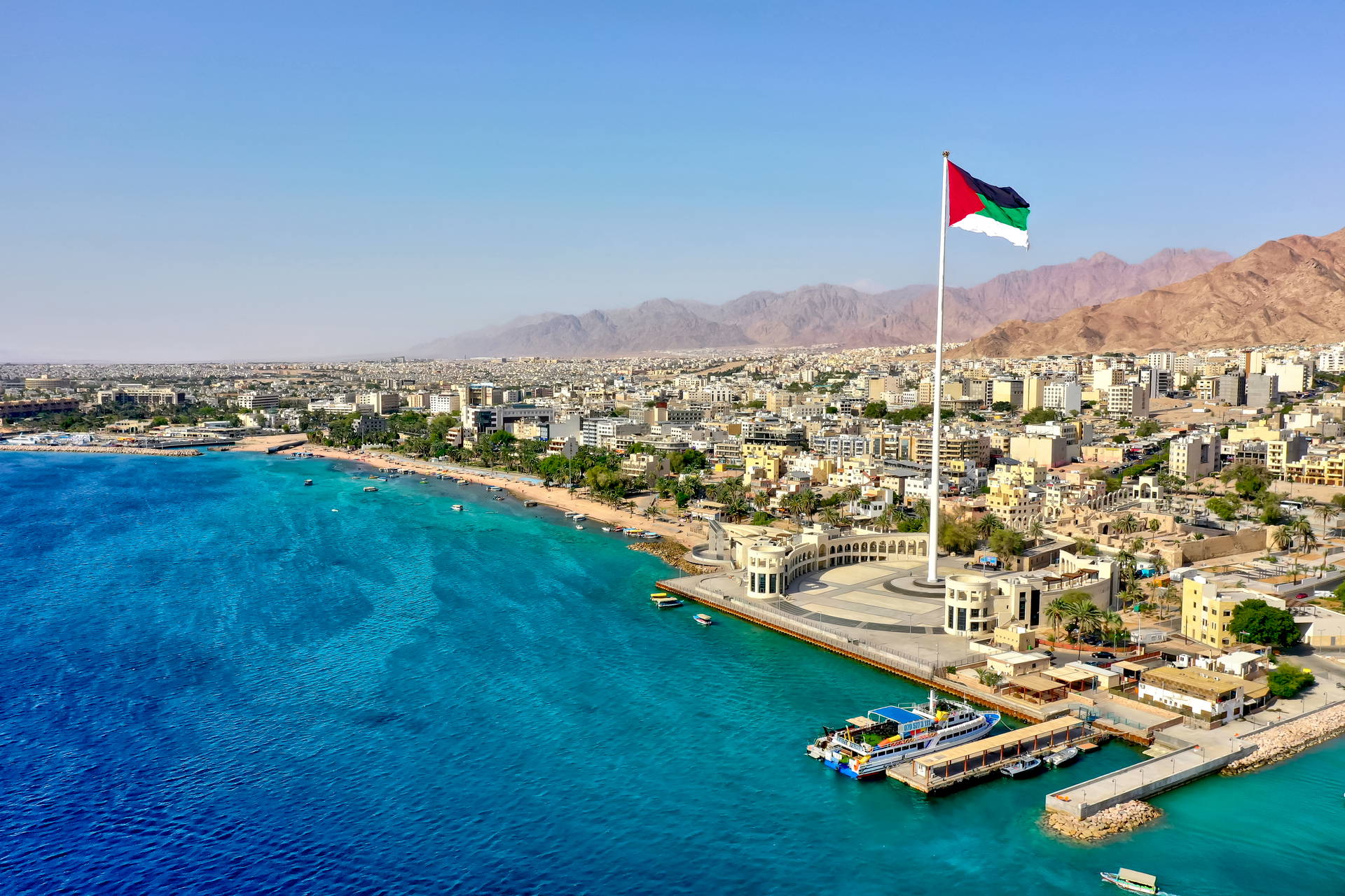Widok na Akabę w Jordanii z flagą miasta na pierwszym planie.