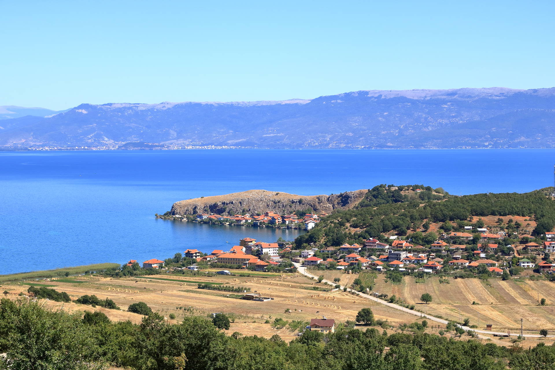 Jezioro otoczone górami i miasteczkiem.