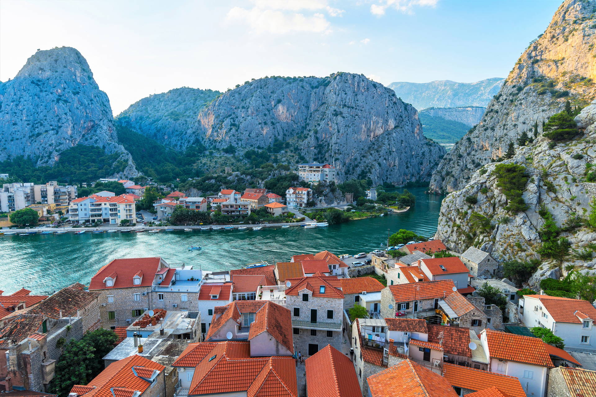 Widok na chorwacki Omiš z rzeką i górami w tle.