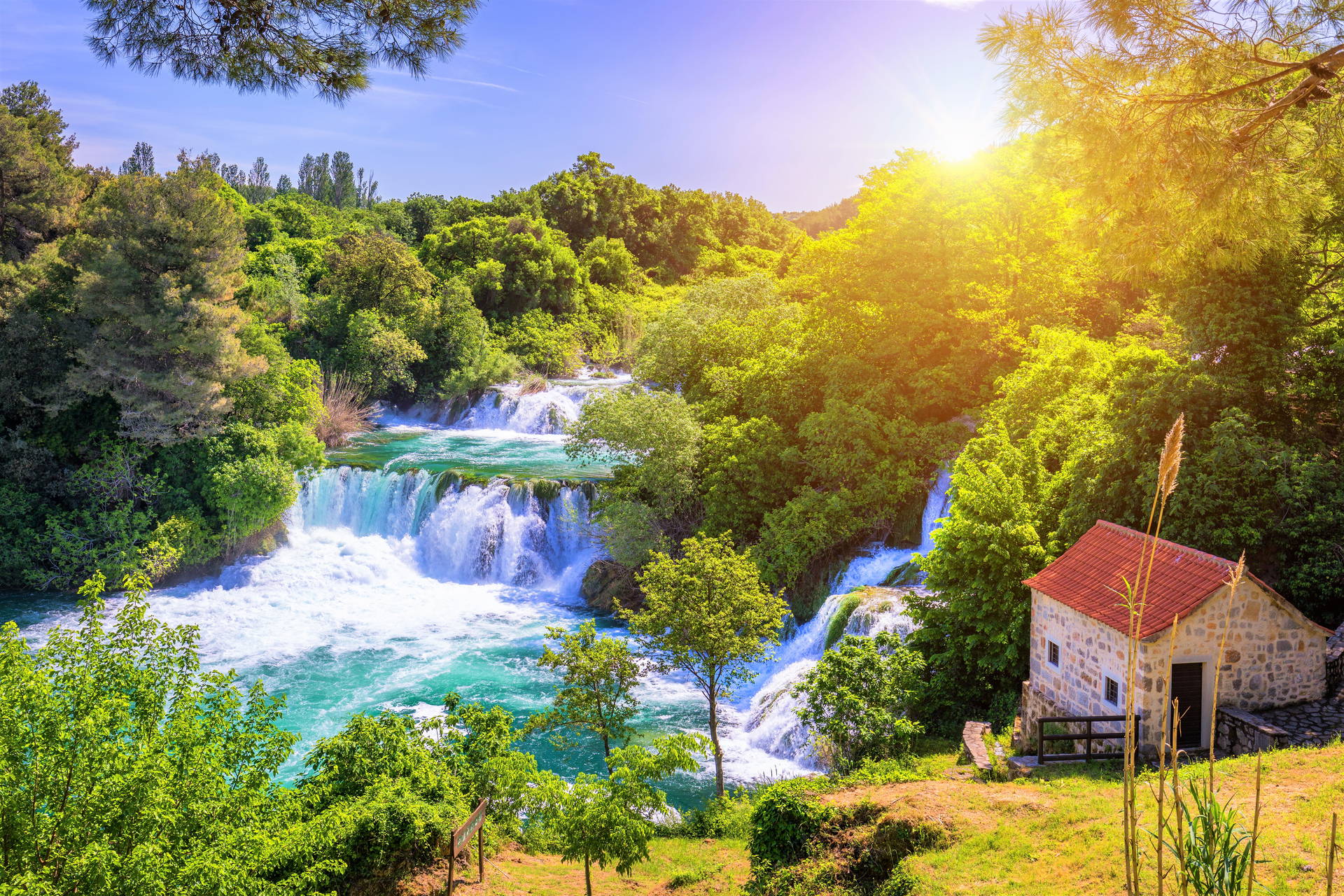 Wodospady Krka w Chorwacji i kamienny budynek na brzegu rzeki.