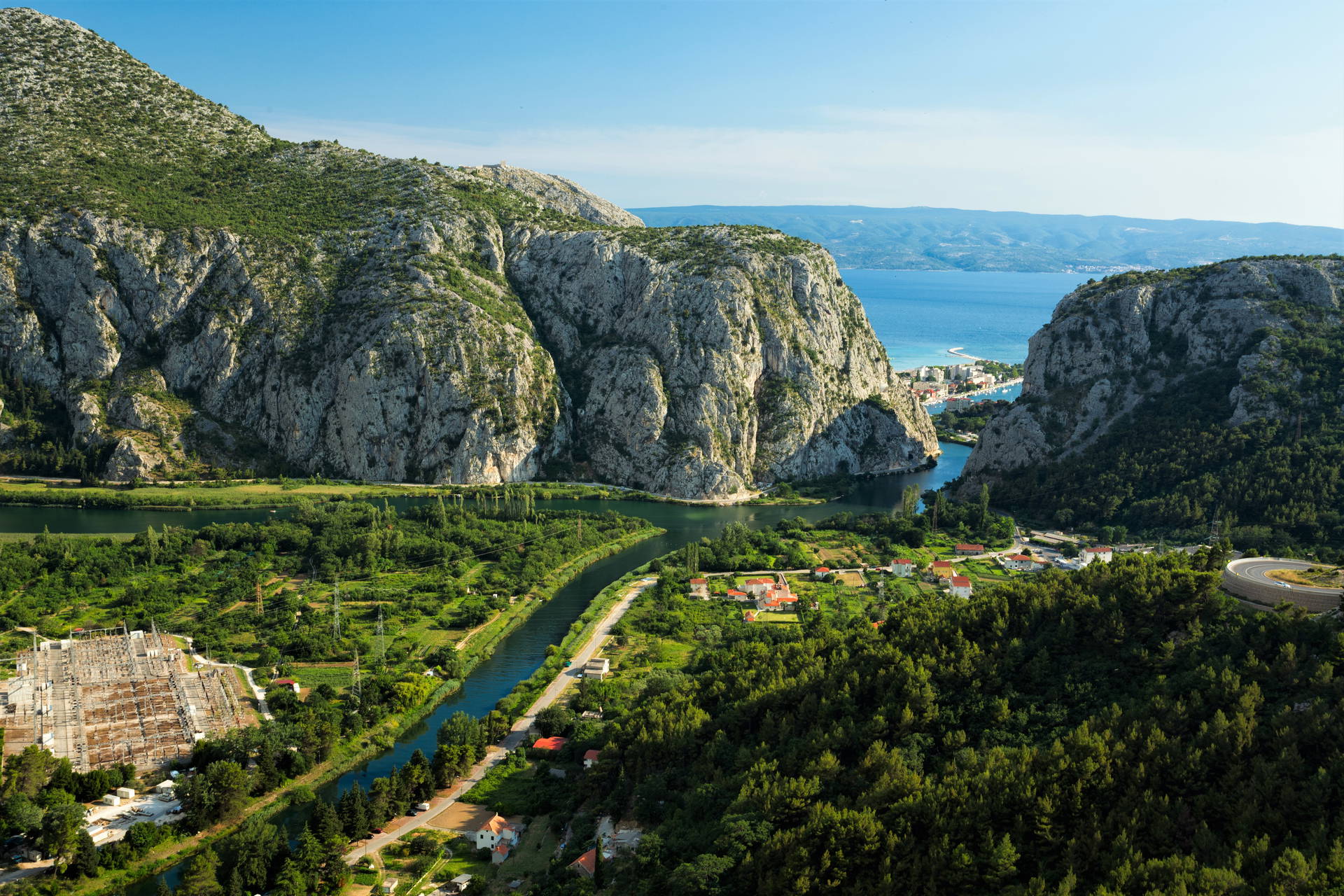 Krajobraz z rzeką Cetiną, górami i miasteczkiem Omiš w Chorwacji.