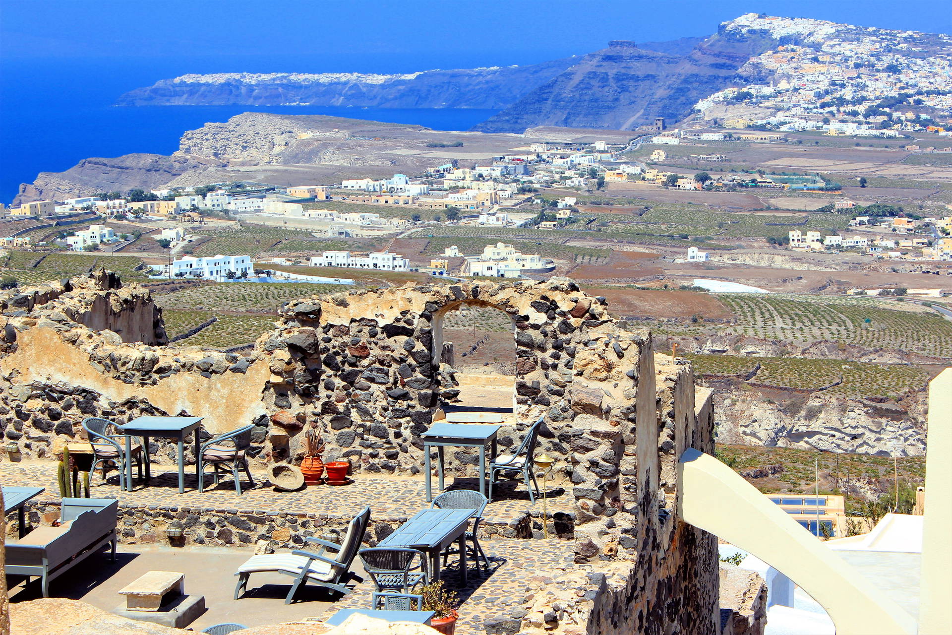 Santorini: ruiny z widokiem na morze i miasto.