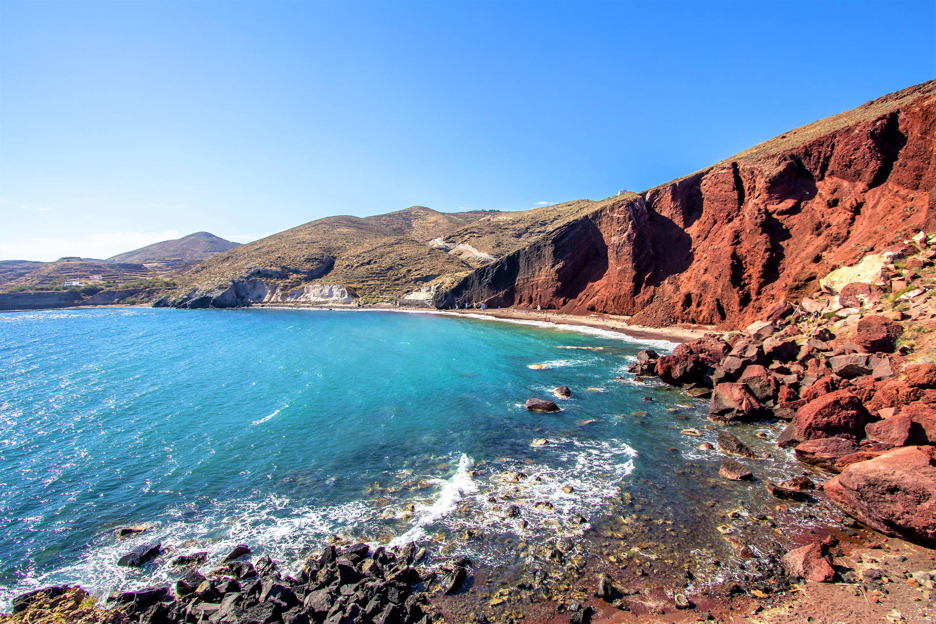 Czerwona Plaża na Santorini z lazurową wodą i klifami.