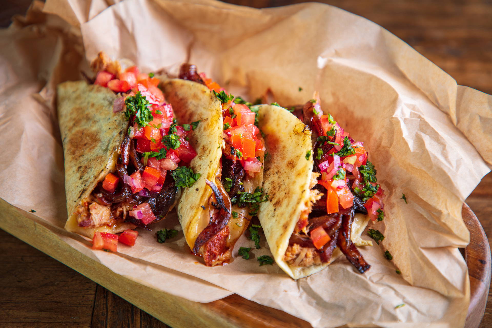 Trzy tacos z mięsem, salsą i ziołami.