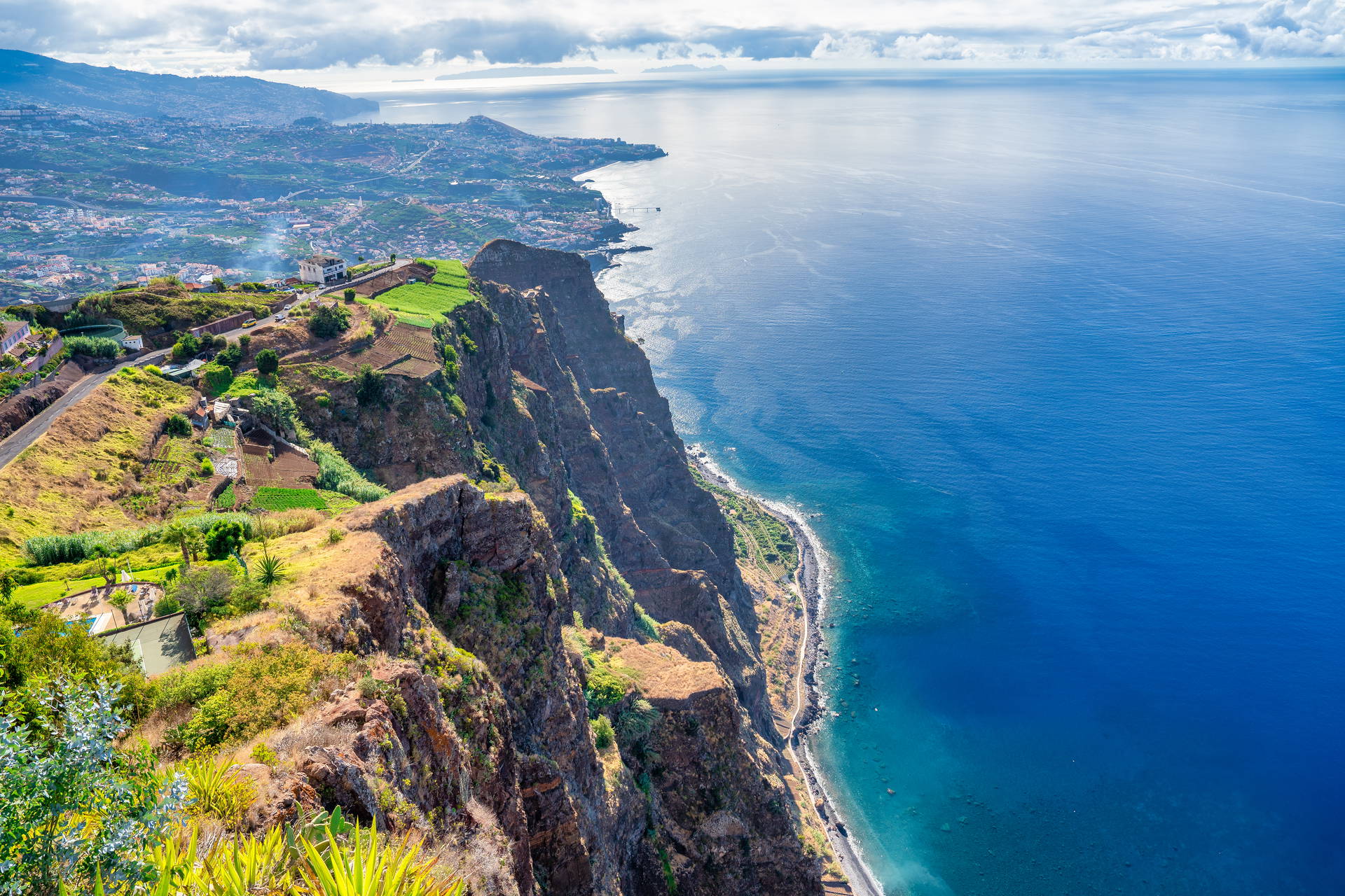 Cabo Girão na Maderze: strome klify, ocean i widok na miasto.