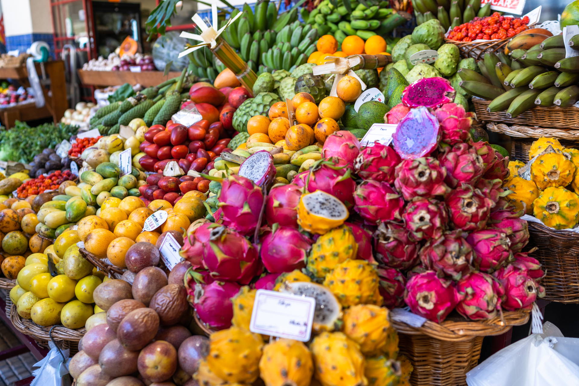 Stoisko na targu z owocami: pitają, mango, marakują i bananami.