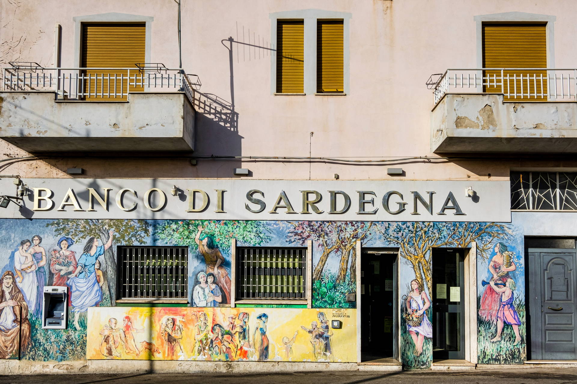 Fasada budynku Banco di Sardegna z muralami.