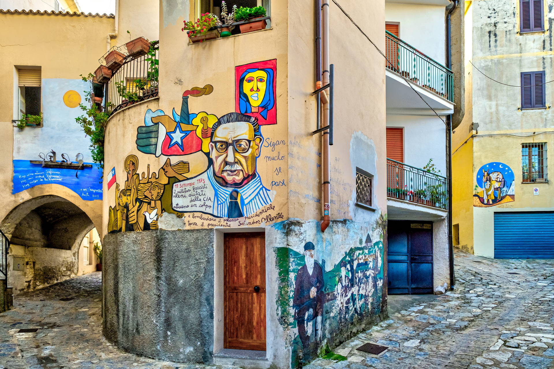 Uliczka w Austis (Sardynia) z budynkami ozdobionymi muralami.