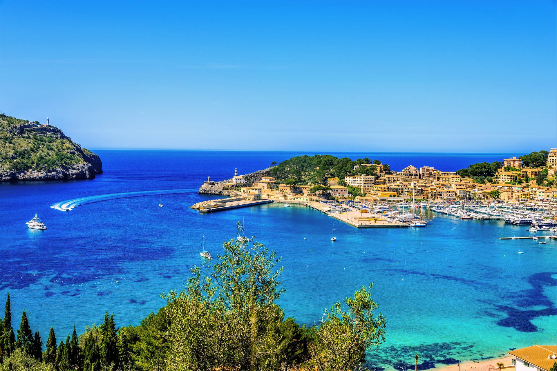Port w Sóller na Majorce z łodziami i budynkami w tle.