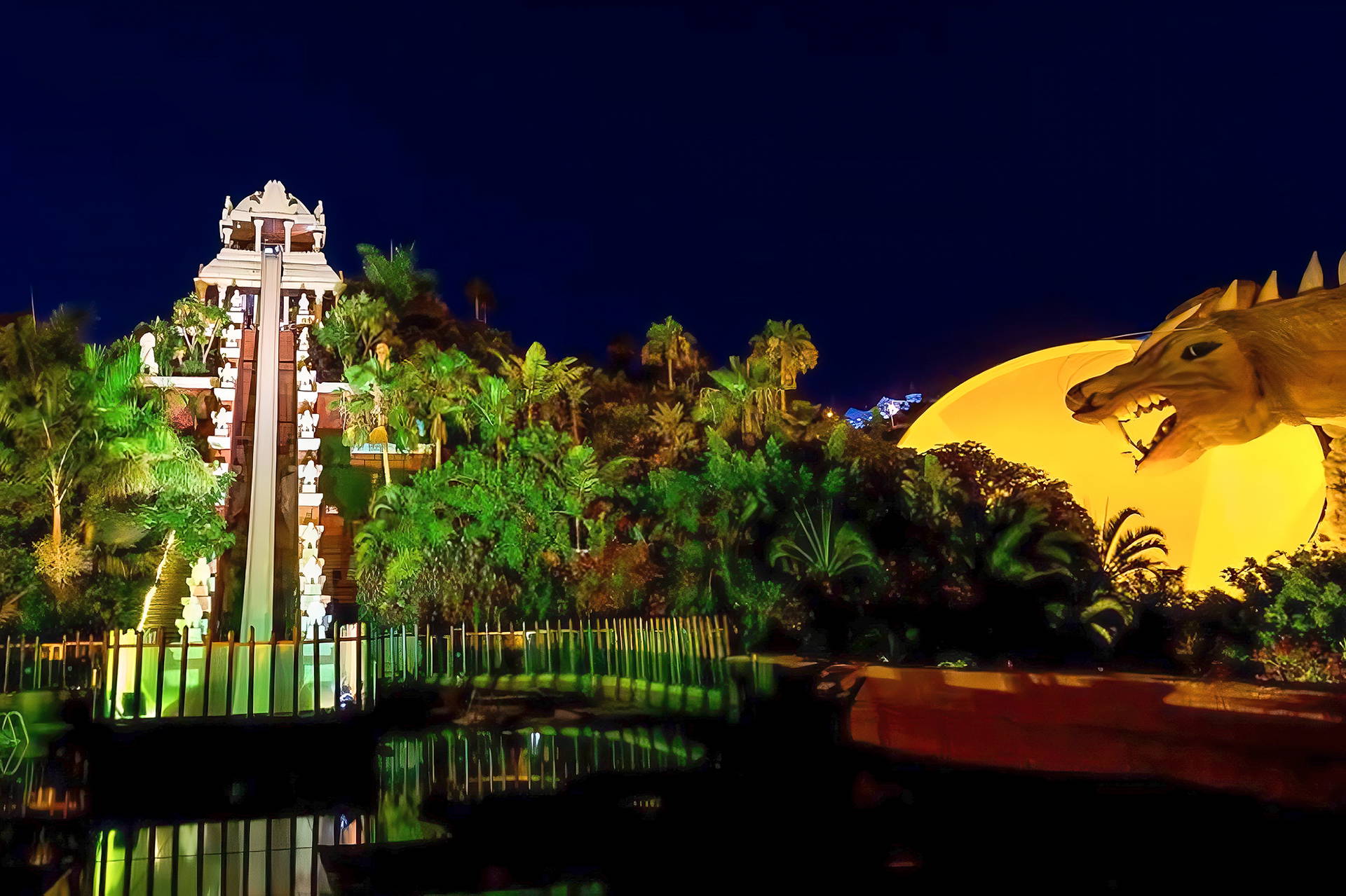 Nocny widok na Siam Park: zjeżdżalnia Tower of Power i głowa smoka.