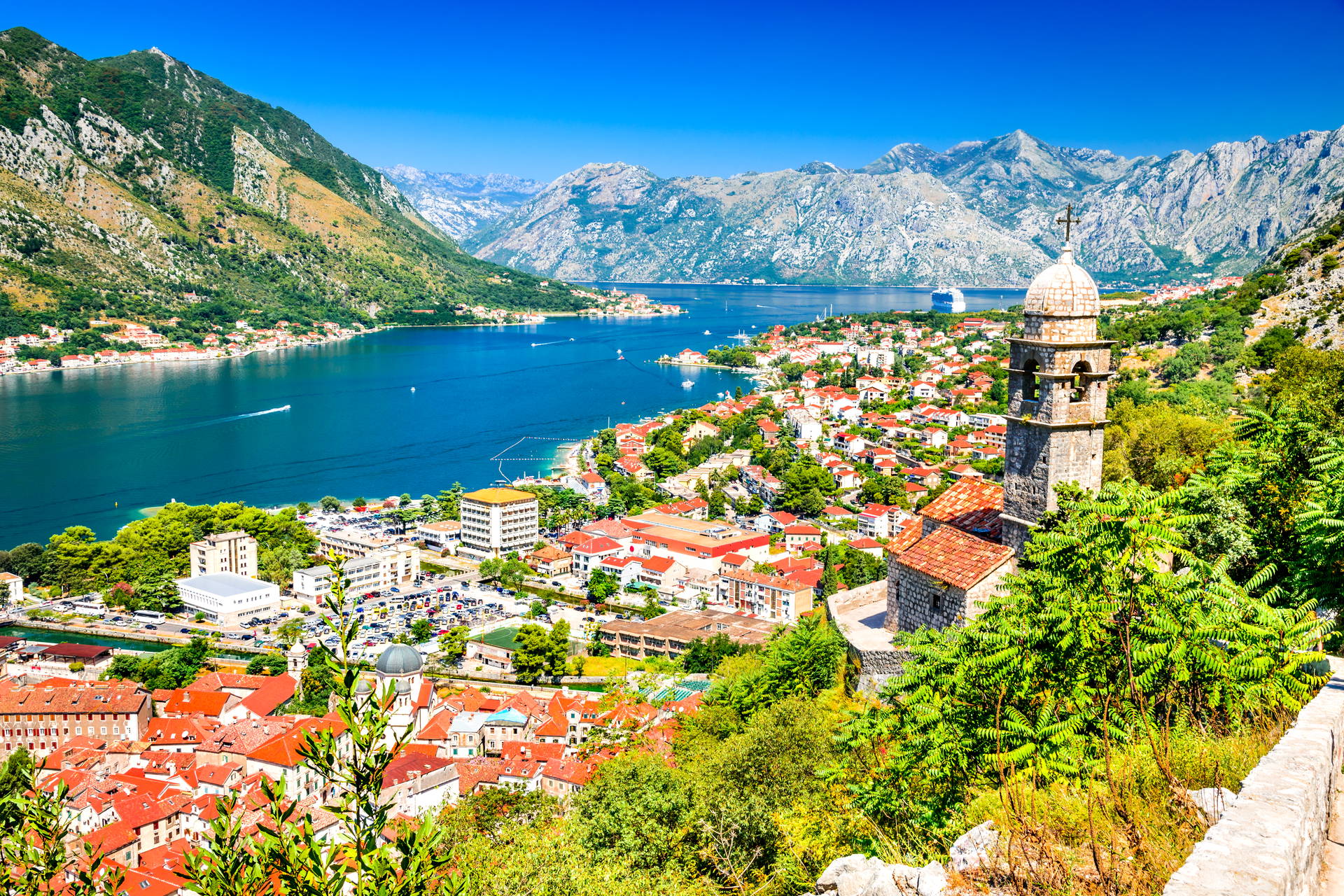Widok na Kotor w Czarnogórze: zatoka, góry i kościół.