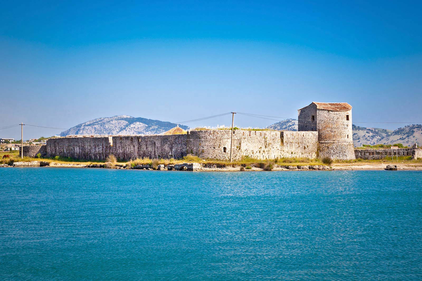 Kamienna twierdza Porto Palermo w Albanii, położona nad wodą.