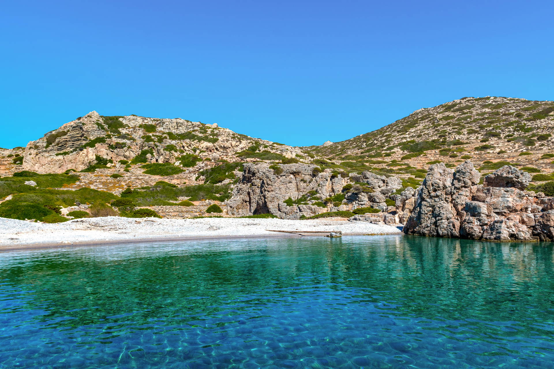 Krystalicznie czysta woda obmywa plażę ze skałami.