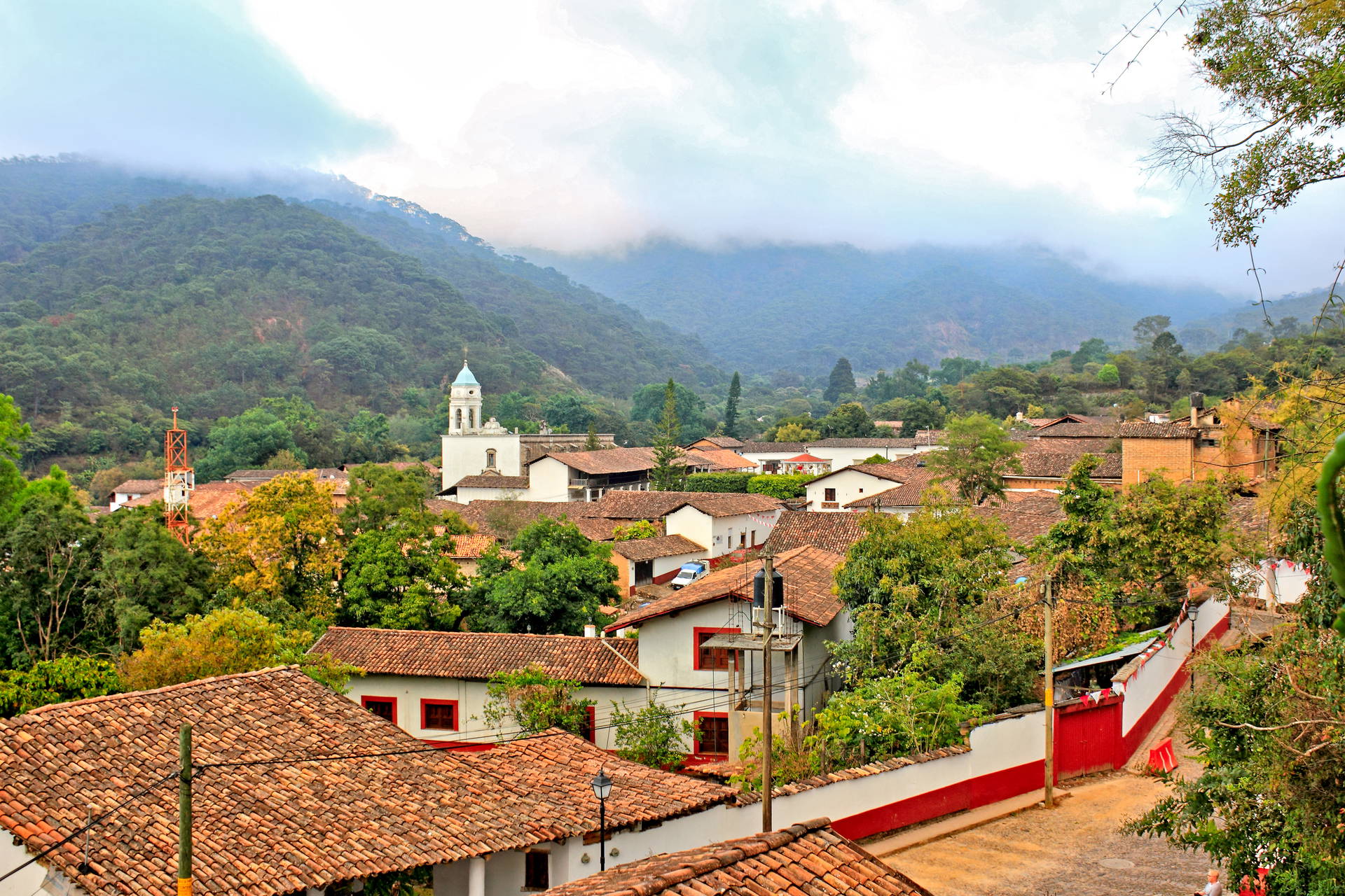 Meksykańskie miasteczko z czerwonymi dachami, na pierwszym planie kościół.