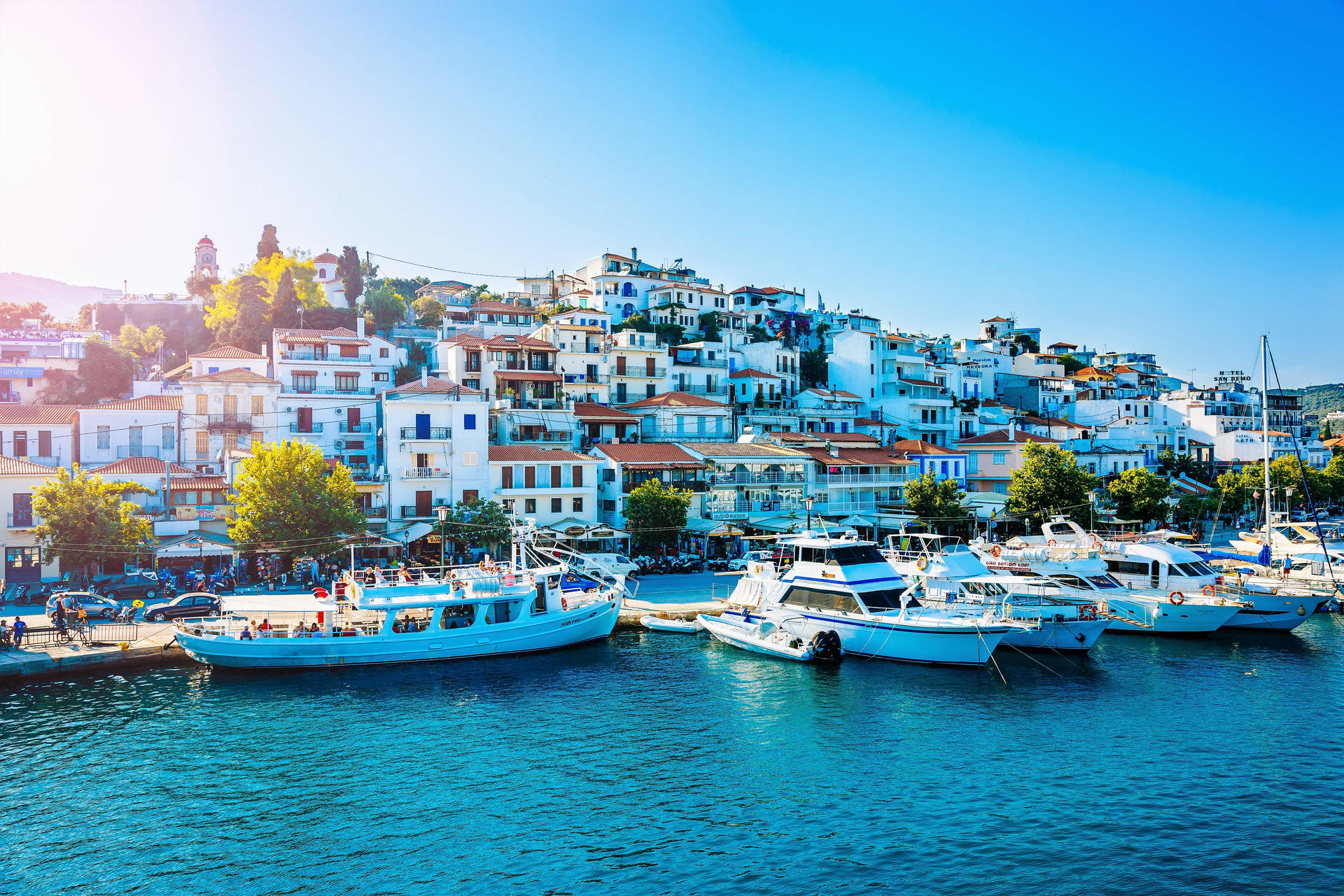 Skiathos, Grecja. Marina z łodziami i białe budynki na wzgórzu w tle.