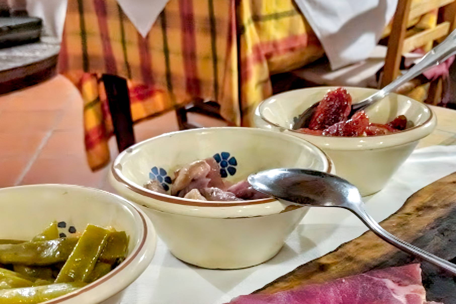 Przystawka z szynki, sera i warzyw na drewnianej desce.