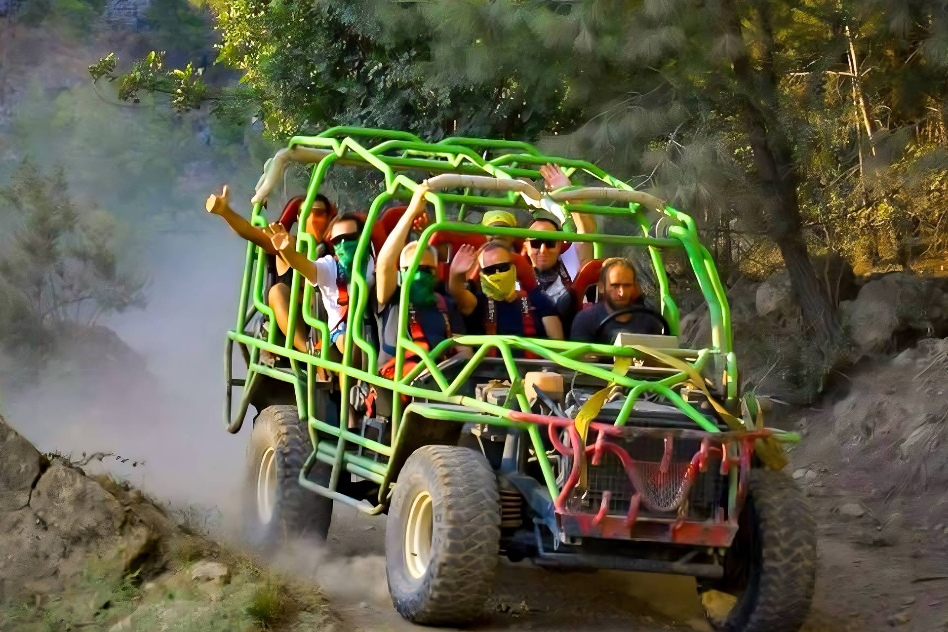 Grupa turystów jedzie zielonym buggy po zakurzonej, leśnej drodze.