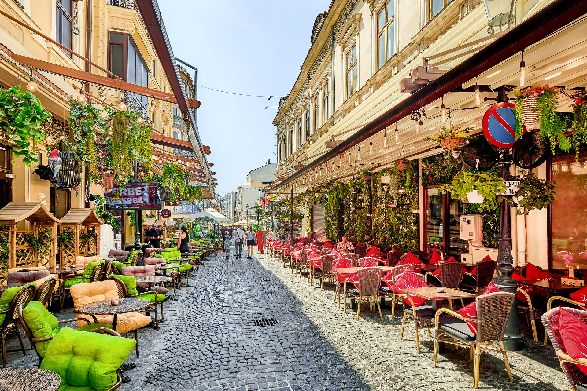 Uliczka na Starym Mieście w Bukareszcie z ogródkami restauracji po obu stronach.