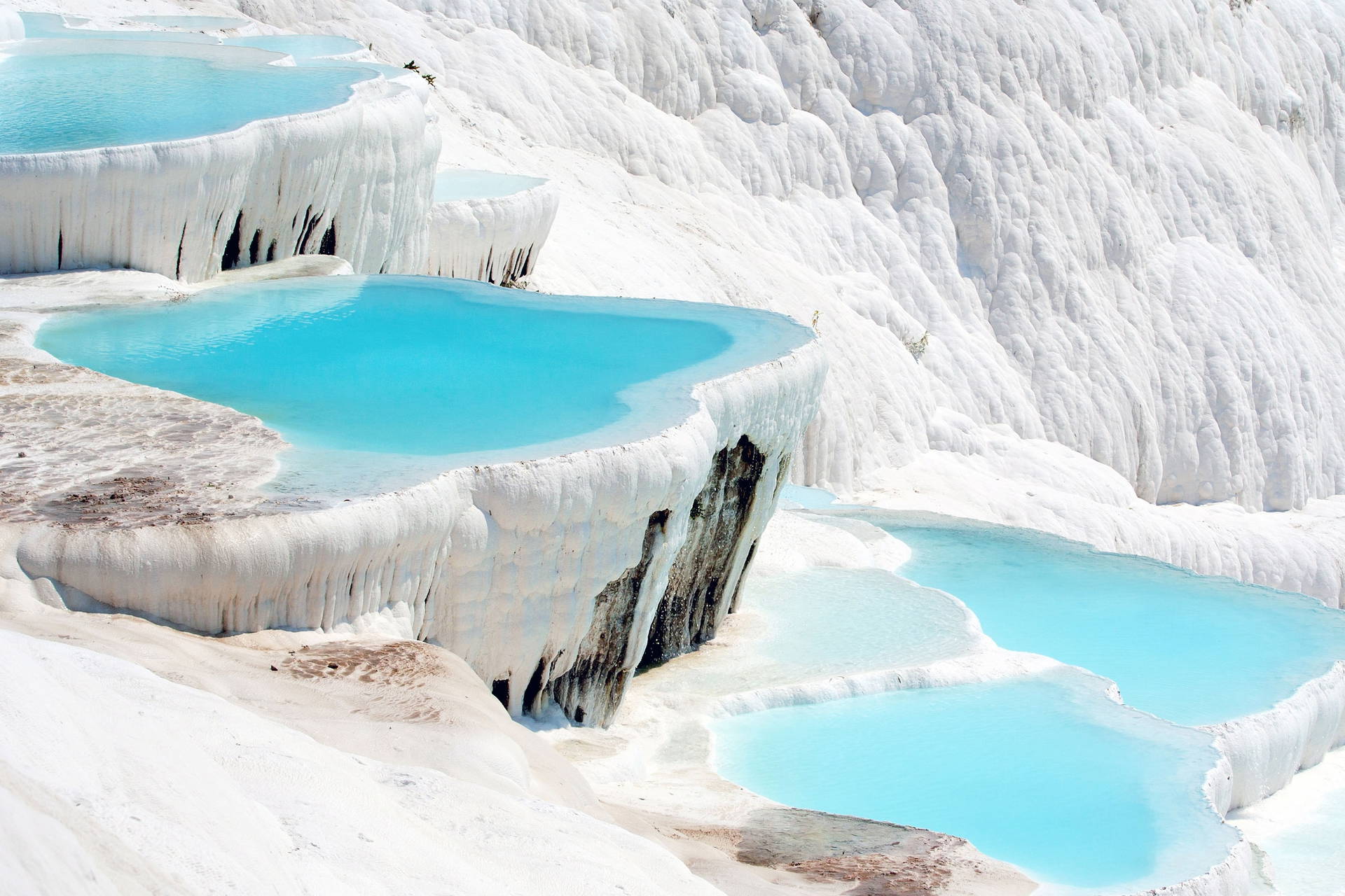 Turkusowe baseny w wapiennych tarasach Pamukkale w Turcji.