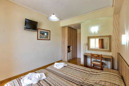 Pokój hotelowy z dwoma łóżkami, telewizorem i toaletką.