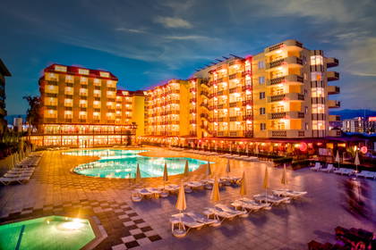 Hotel z basenem oświetlonym nocą.