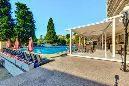 Hotelowy basen z leżakami i parasolami.