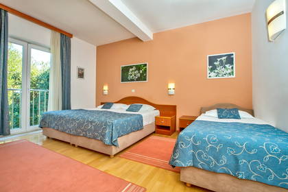 Pokój hotelowy z dwoma łóżkami i balkonem.