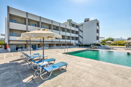 Hotel z basenem i leżakami do opalania.