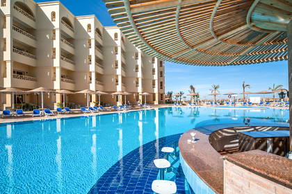 Basen hotelowy z barem wodnym i leżakami.