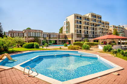 Kompleks hotelowy z basenem na pierwszym planie.