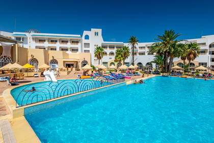 Kompleks hotelowy z basenem i palmami.