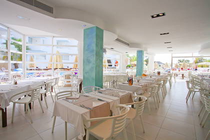 Jasna restauracja z widokiem na basen.