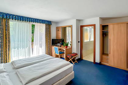 Pokój hotelowy z łóżkiem, biurkiem i szafą.