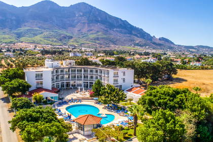 Hotel z basenem i góra w tle, widok z lotu ptaka.