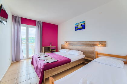Pokój hotelowy z dwoma łóżkami i balkonem.