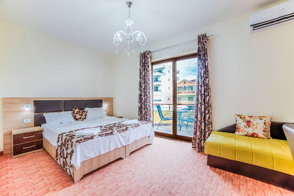 Pokój hotelowy z łóżkiem, sofą i balkonem.