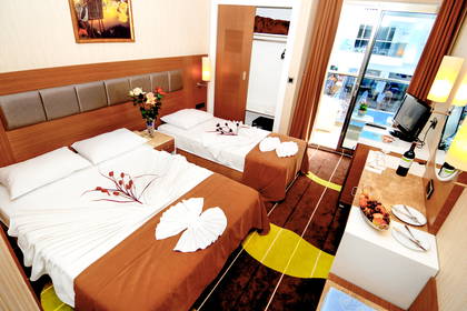 Pokój hotelowy z dwoma łóżkami, balkonem oraz powitalnymi owocami i winem.