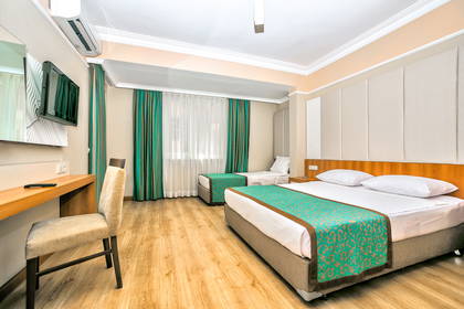 Pokój hotelowy z dwoma łóżkami, biurkiem i telewizorem.