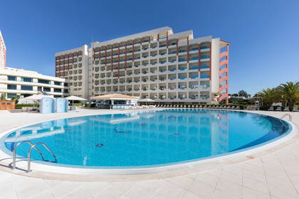 Hotel z basenem w słoneczny dzień.