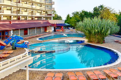 Kompleks basenowy z leżakami przy hotelu.