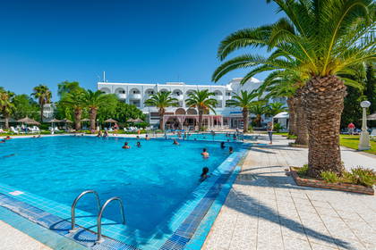 Basen z palmami przy hotelu.