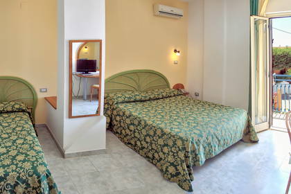 Pokój hotelowy z dwoma łóżkami, balkonem i lustrem.