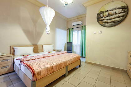 Pokój hotelowy z łóżkiem, szafką nocną i okrągłym obrazem na ścianie.