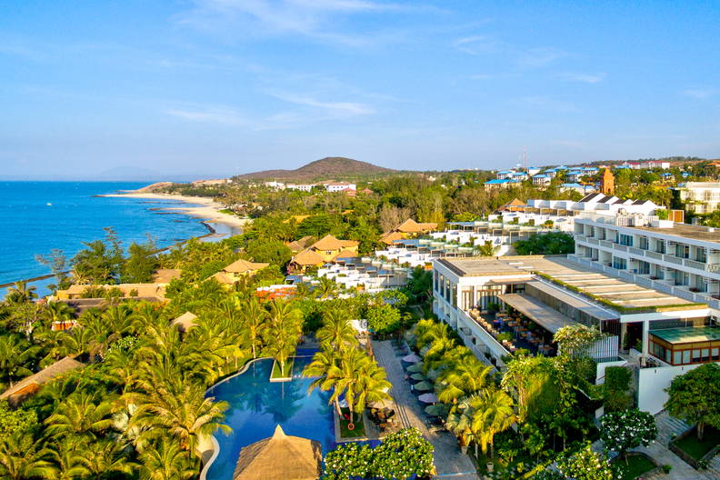 Kurort nad morzem z basenem i palmami, widok z góry.