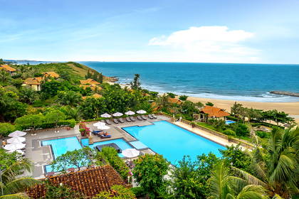 Hotel z basenem przy plaży nad oceanem.