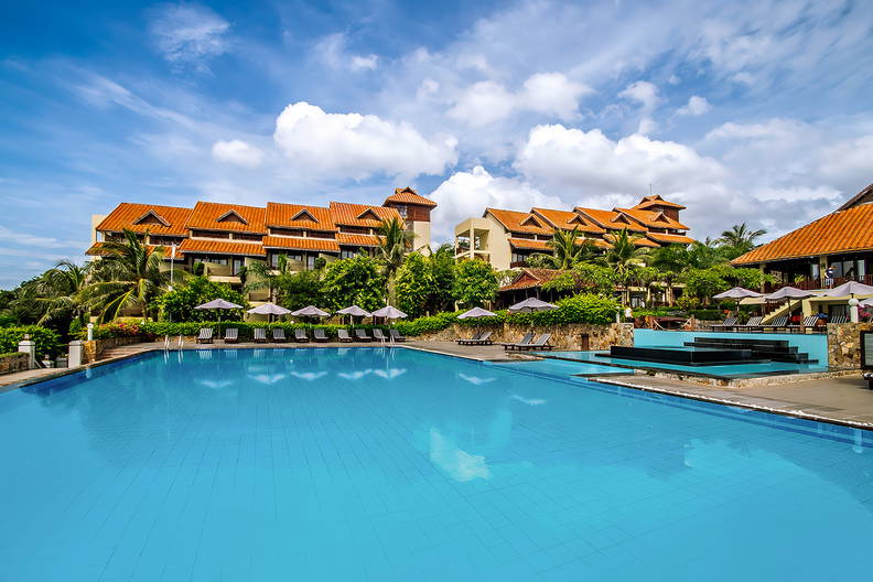 Duży basen z błękitną wodą w luksusowym kurorcie.