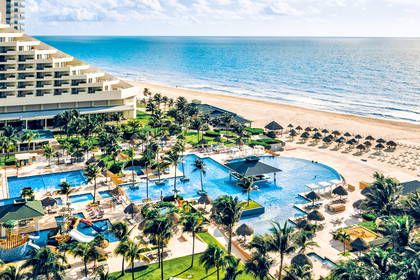 Widok z lotu ptaka na luksusowy hotel z basenami przy plaży.