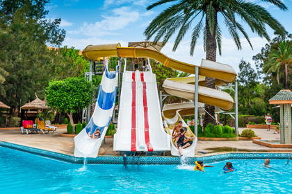 Aquapark: dzieci zjeżdżają ze zjeżdżalni do basenu.