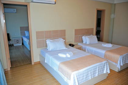 Pokój hotelowy z dwoma łóżkami i widokiem na inny pokój.