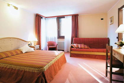 Pokój hotelowy z łóżkiem, sofą i biurkiem do pracy.